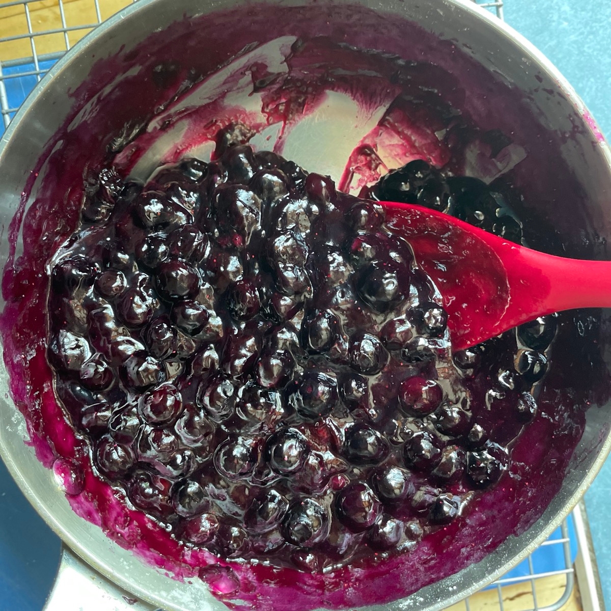 Fresh blueberries simmered in a saucepan with water, cornstarch, and sugar.