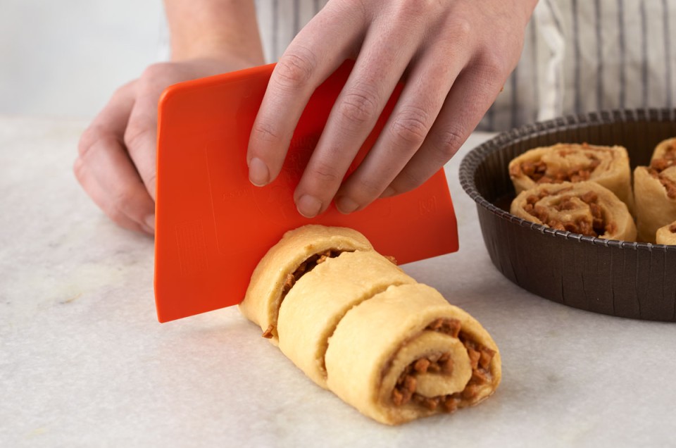 Using dough scraper to cut rolls