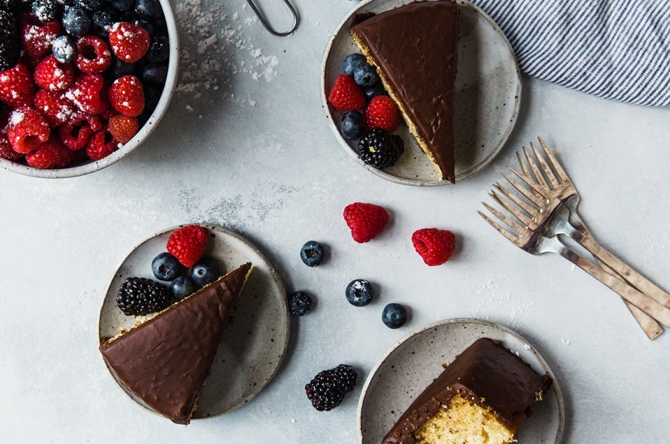 Classic Yellow Cake with Fudge Frosting served on plates with berries - select to zoom