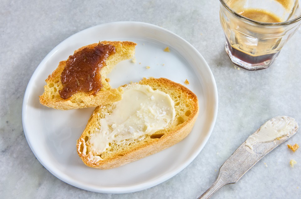 Semolina Baguette sliced on a plate and topped with butter and jam - select to zoom