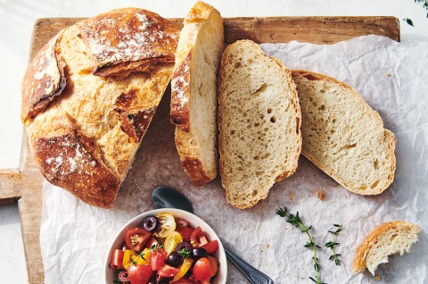 A loaf of crusty bread that has a few slices cut off, showing off the thin and crisp crust and even interior structure. - select to zoom