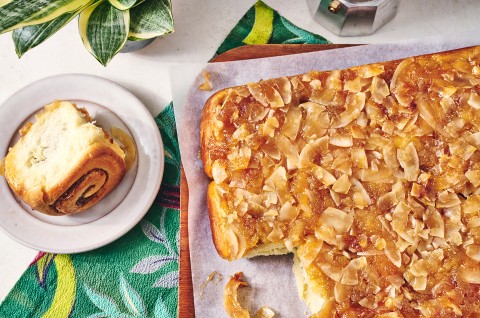 Pineapple Upside-Down Rolls on parchment with one roll out - select to zoom