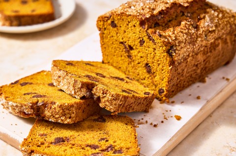 A loaf of The Most Pumpkin Pumpkin Chocolate Chip Bread with a few slices cut out of it - select to zoom