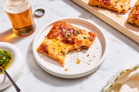 A slice of Flaky Puff Crust Pizza on a plate with a bite taken out of it - select to zoom