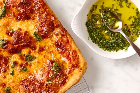 A full Flaky Puff Crust Pizza and a dish of basil oil - select to zoom