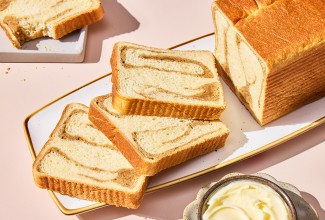 A sliced loaf of Swirled Maple Milk Bread on a serving tray