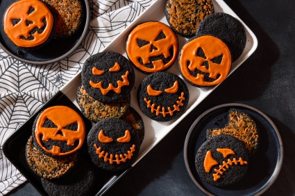 chocolate cookies decorated as jack o lanterns on a plate