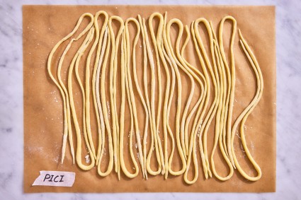 Pici pasta shape on a parchment-line baking sheet