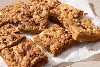 Squares of cut up blondies resting on a piece of parchment.