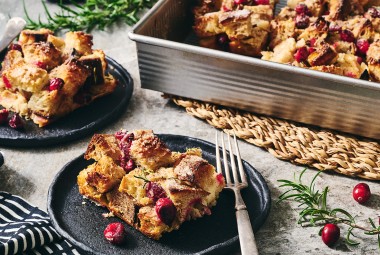 Cranberry-Rosemary Breakfast Bread Pudding on plates and in a pan.
